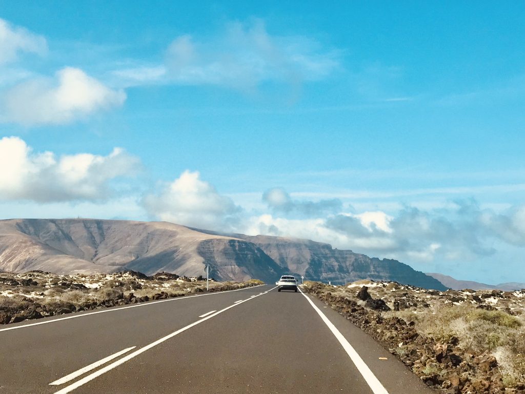 Views of a mountain landscape with blue skies, taken from a road